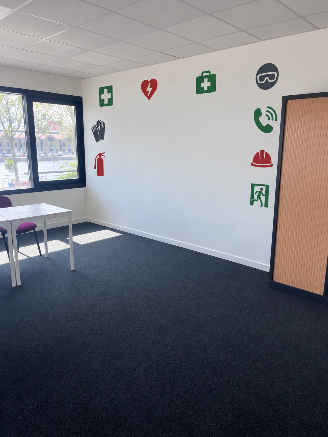 Pictogrammes de sécurité imprimés sur un mur blanc